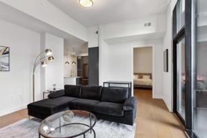 sala de estar con sofá negro y mesa de cristal en Midtown Luxury Apartment en Atlanta