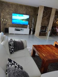 a living room with a couch and a flat screen tv at Bungalov Valentýna in Mikulov
