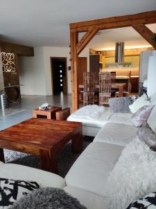 a living room with white couches and a wooden table at Bungalov Valentýna in Mikulov