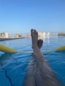 een persoon die op zijn voeten in het water ligt bij Pool House Stamato in Kineta