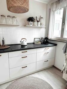 uma cozinha com armários brancos e um balcão preto em Zentrale Wohnung + Dachterrasse em Sonthofen