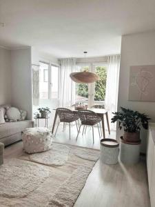 uma sala de estar com um sofá, uma mesa e cadeiras em Zentrale Wohnung + Dachterrasse em Sonthofen