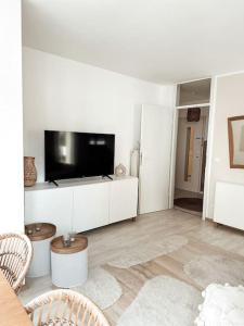 a white living room with a flat screen tv at Zentrale Wohnung + Dachterrasse in Sonthofen