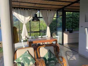 ein Esszimmer mit einem Tisch, Stühlen und Fenstern in der Unterkunft Casa en Chivor a 3 hrs de Bogota in Macanal