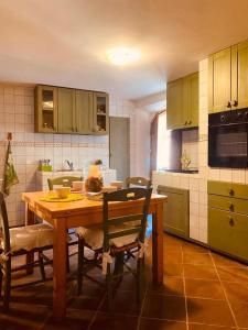 eine Küche mit einem Holztisch mit Stühlen und einer Mikrowelle in der Unterkunft Alloggio turistico S.Pellegrino 45 in Viterbo