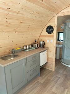 a kitchen in a log cabin with a sink at Gateway Glamping in Farranfore