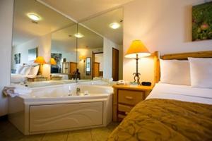 a hotel room with a tub and a bed at Cranberry Country Lodge in Tomah