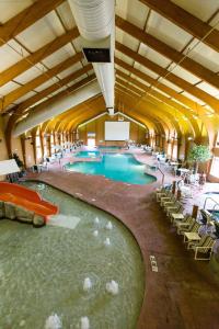 une grande piscine intérieure avec des personnes assises autour de celle-ci dans l'établissement Cranberry Country Lodge, à Tomah