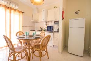 uma cozinha com uma mesa e cadeiras e um frigorífico em Sunset Vau em Portimão