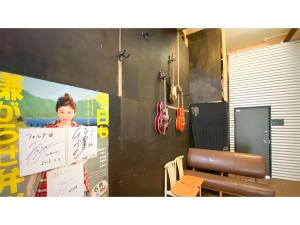 Uma mulher está atrás de um cartaz numa sala. em Forte "Hachijojima" - Vacation STAY 62479v em Hachijo