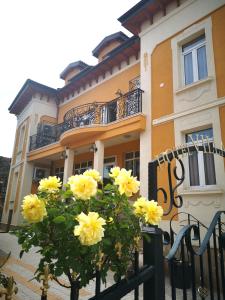 un edificio con flores amarillas delante de una valla en Villa Paris en Hisarya