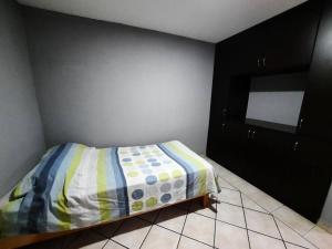 1 dormitorio pequeño con 1 cama y armario negro en casa amueblada en cuernavaca Casa Luz, en Cuernavaca