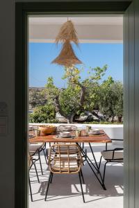 une table et des chaises devant une fenêtre dans l'établissement Olivine Paros Villas, à Parikia