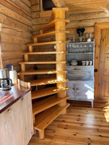 a staircase in a log cabin with a kitchen at Nuustakumajad in Otepää