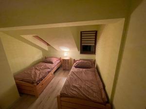 two beds in a small room with a attic at Domek w Koszarawie Bystrej in Koszarawa