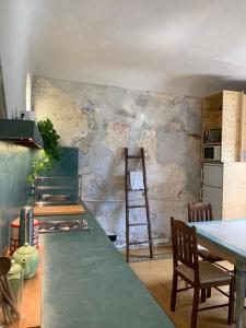 una cucina con tavolo e un muro con scala di Appartmento nel mercato centrale di San Lorenzo a Firenze