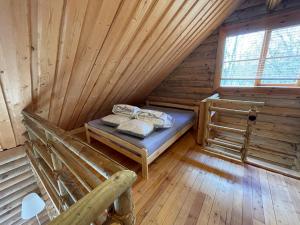 Habitación con cama en una cabaña de madera en Nuustakumajad, en Otepää