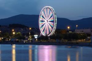 a large ferris wheel in the water at night at Apartments Babic in Podstrana