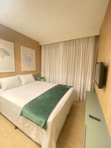 a bedroom with a large bed and a television at Excelente Apto 1Q St Marista - 453 in Goiânia