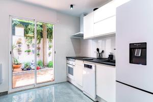 eine Küche mit weißen Schränken und einem großen Fenster in der Unterkunft Casa la Fontana in Granada