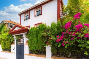 a white house with pink flowers in front of it at Casa la Fontana in Granada