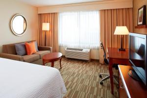 a hotel room with a bed and a television at Courtyard Denver South Park Meadows Mall in Centennial