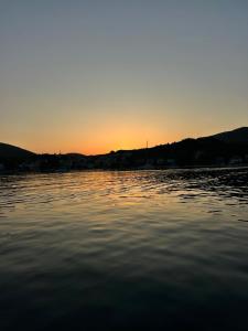 a body of water with a sunset in the background at Apartments Babic in Podstrana