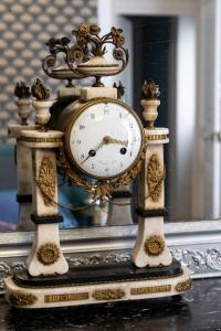 une horloge or assise sur une table devant un miroir dans l'établissement Demeure Belle Epoque, à Reims
