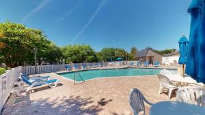 a swimming pool with chairs and a table at Osprey Watch 4D in Pawleys Island