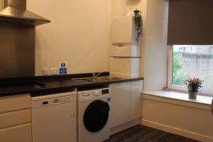 a kitchen with a washing machine and a window at The Arches The Wee Yin in Stirling