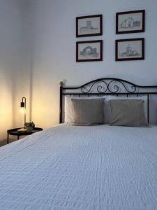 a bedroom with a white bed with three pictures on the wall at Casa da Vila - Vilar Maior, Sabugal in Vilar Maior