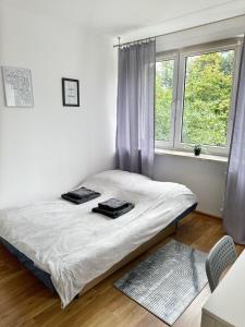 a bed sitting in a room with a window at Anielewicza 26 Rooms in Warsaw