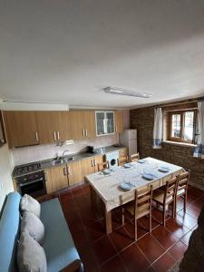 a kitchen with a table and a blue couch at Casa da Vila - Vilar Maior, Sabugal in Vilar Maior