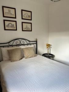 a bedroom with a white bed with three pictures on the wall at Casa da Vila - Vilar Maior, Sabugal in Vilar Maior