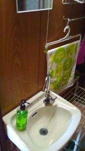un lavabo con una botella de jabón verde. en Mixed Dormitory 6beds room- Vacation STAY 14724v en Morioka