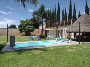 a backyard with a swimming pool and a house at Casa de descanso alberca climatizada in Atlixco