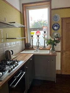 a kitchen with a sink and a stove and a window at Stunning Whitley Bay apartment in Whitley Bay
