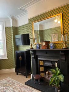 a living room with a fireplace and a mirror at Stunning Whitley Bay apartment in Whitley Bay