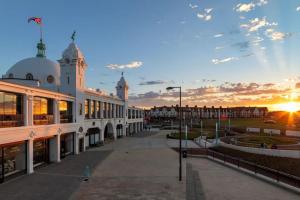 a view of a building with a sunset in the background at Stunning Whitley Bay apartment in Whitley Bay