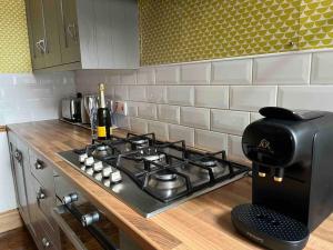 a kitchen counter with a stove and a coffee maker at Stunning Whitley Bay apartment in Whitley Bay
