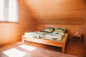 コパリノにあるDomki U Edziaのキャビン内の木造の部屋のベッド1台