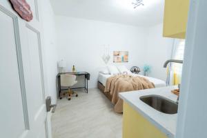 1 dormitorio con cama, escritorio y lavamanos en The Hidden Cottage en Welches Hill