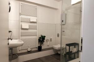a white bathroom with a toilet and a sink at cameiroo - Apartment Euskirchen in Euskirchen +14 photos