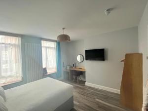 a bedroom with a bed and a desk with a television at No.5 in Derry Londonderry +42 photos