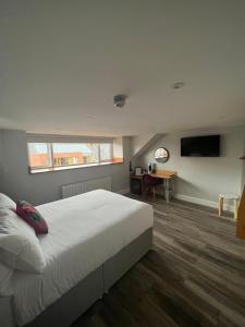 a bedroom with a large white bed and a desk at No.5 in Derry Londonderry