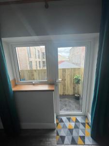 una camera con due finestre e un pavimento a scacchi di No.5 a Londonderry