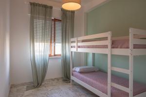 a bedroom with two bunk beds and a window at Un posto al sole in Monopoli