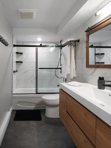 a bathroom with a shower and a toilet and a sink at Chalet Détente Orford in Orford