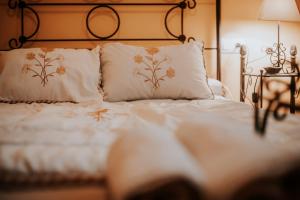 ein Bett mit weißer Bettwäsche und Kissen in einem Schlafzimmer in der Unterkunft Conde de la Encina 16 in Trujillo