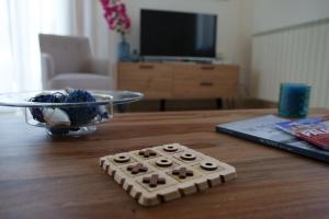 a remote control sitting on top of a wooden table at Le Vele Mondello, villa a due passi dal mare in Mondello